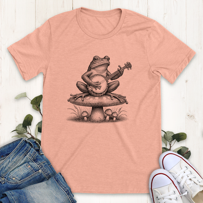 Heather peach Banjo frog on a mushroom graphic t-shirt by Thistle and Brass